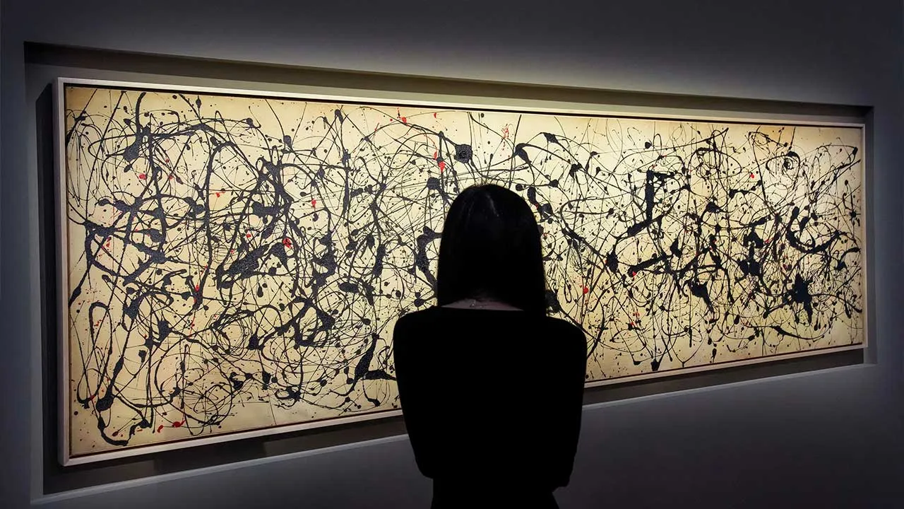 A person watches the artwork titled Number 7A, dated 1948 by Jackson Pollock during the Christie's preview for the 20/21 Spring Marquee Week in New York City, U.S., May 8, 2026. REUTERS/Eduardo Munoz