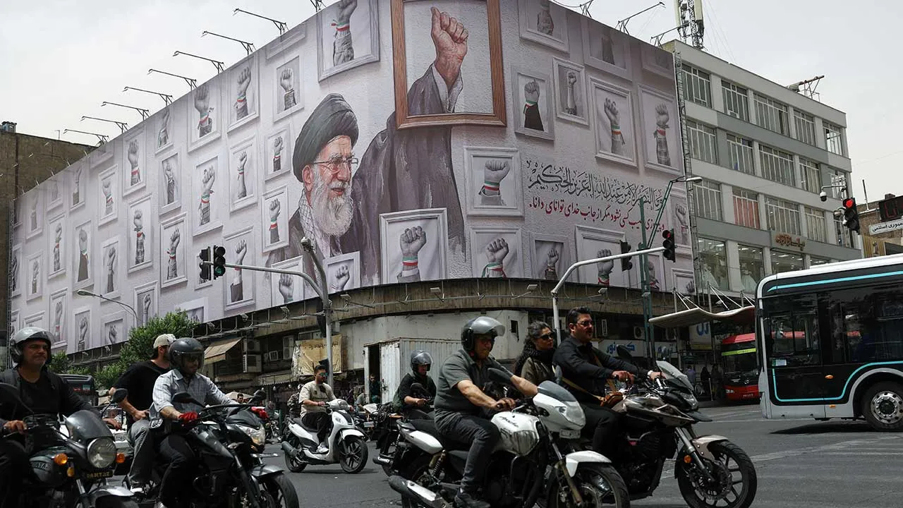 People ride motorcycles near a billboard with an image of the late Iranian Supreme Leader Ayatollah Ali Khamenei, in Tehran, Iran, May 19, 2026. Majid Asgaripour/WANA (West Asia News Agency) via REUTERS ATTENTION EDITORS - THIS PICTURE WAS PROVIDED BY A THIRD PARTY