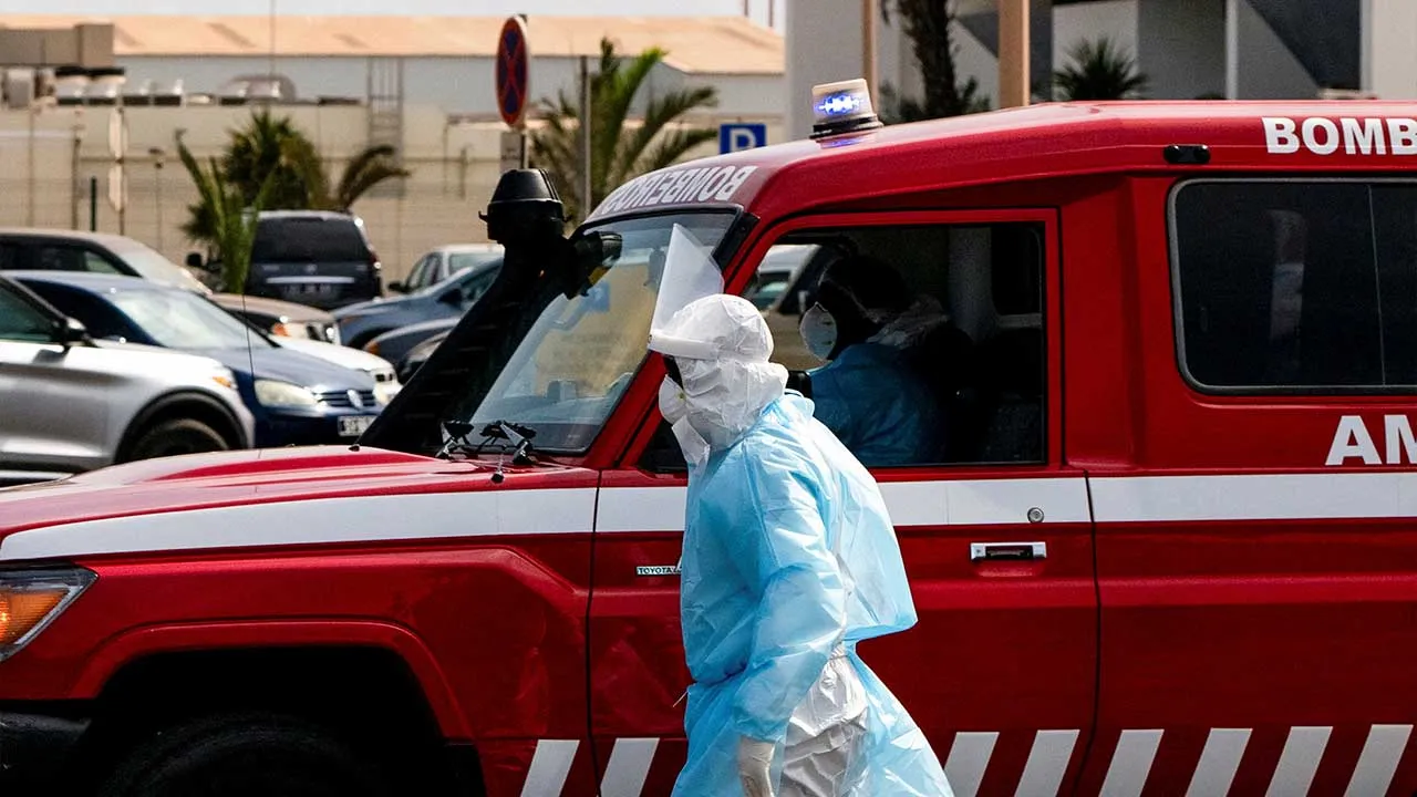 A person in protective clothing walks next to an ambulance during an evacuation operation of suspected hantavirus patients, following an outbreak on the cruise ship MV Hondius, in Praia, Cape Verde, May 6, 2026. REUTERS/Danilson Sequeira