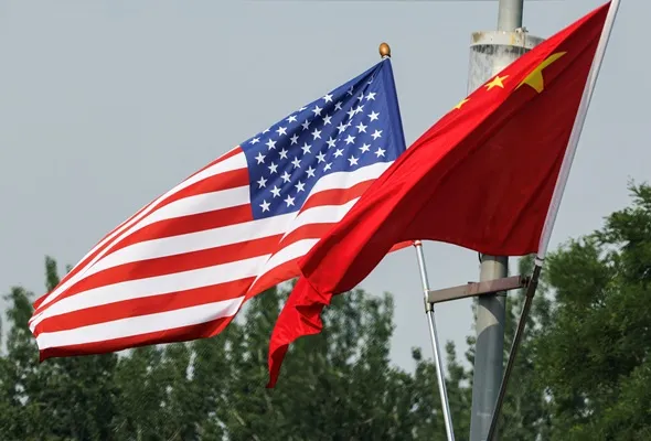 National flags of China and the United States flutter on a road, ahead of the U.S. President Donald Trump's state visit to China, in Beijing, China, May 13, 2026. REUTERS/Tingshu Wang