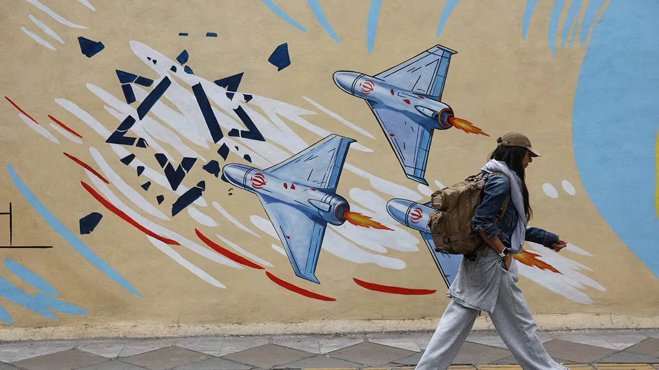 An Iranian woman walks next to an anti-Israeli mural on a street in Tehran, Iran, May 5, 2026. Majid Asgaripour/WANA (West Asia News Agency) via REUTERS