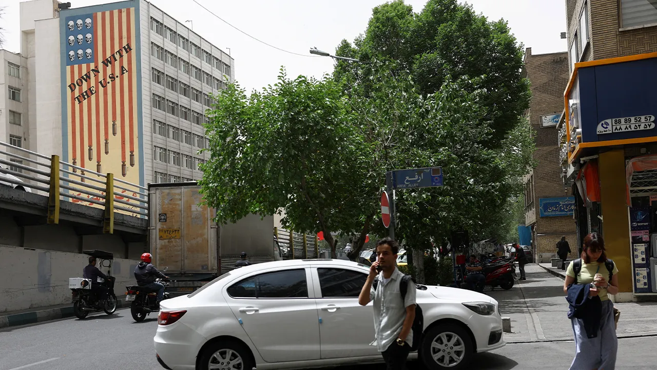 People walk near an anti-U.S. mural on a building in Tehran, Iran, May 19, 2026. Majid Asgaripour/WANA (West Asia News Agency) via REUTERS ATTENTION EDITORS - THIS PICTURE WAS PROVIDED BY A THIRD PARTY