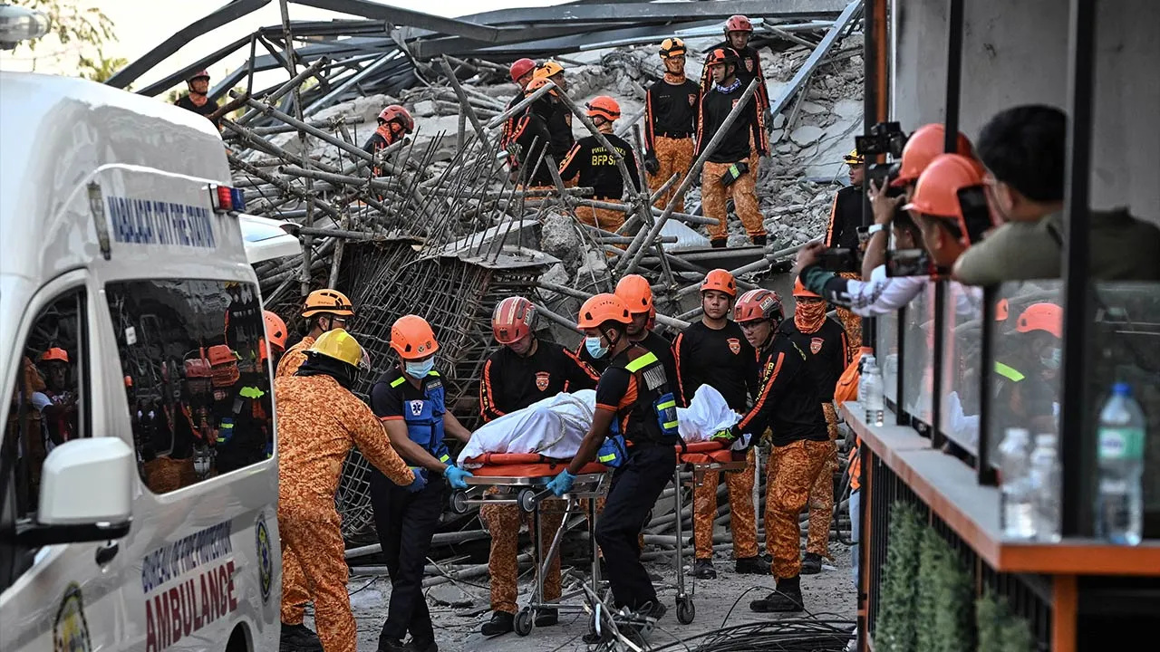 Rescue workers retrieve the body of a victim among debris as a nine-story building under construction collapsed in Balibago, Angeles City, Pampanga, Philippines, May 24, 2026. REUTERS/Noel Celis
