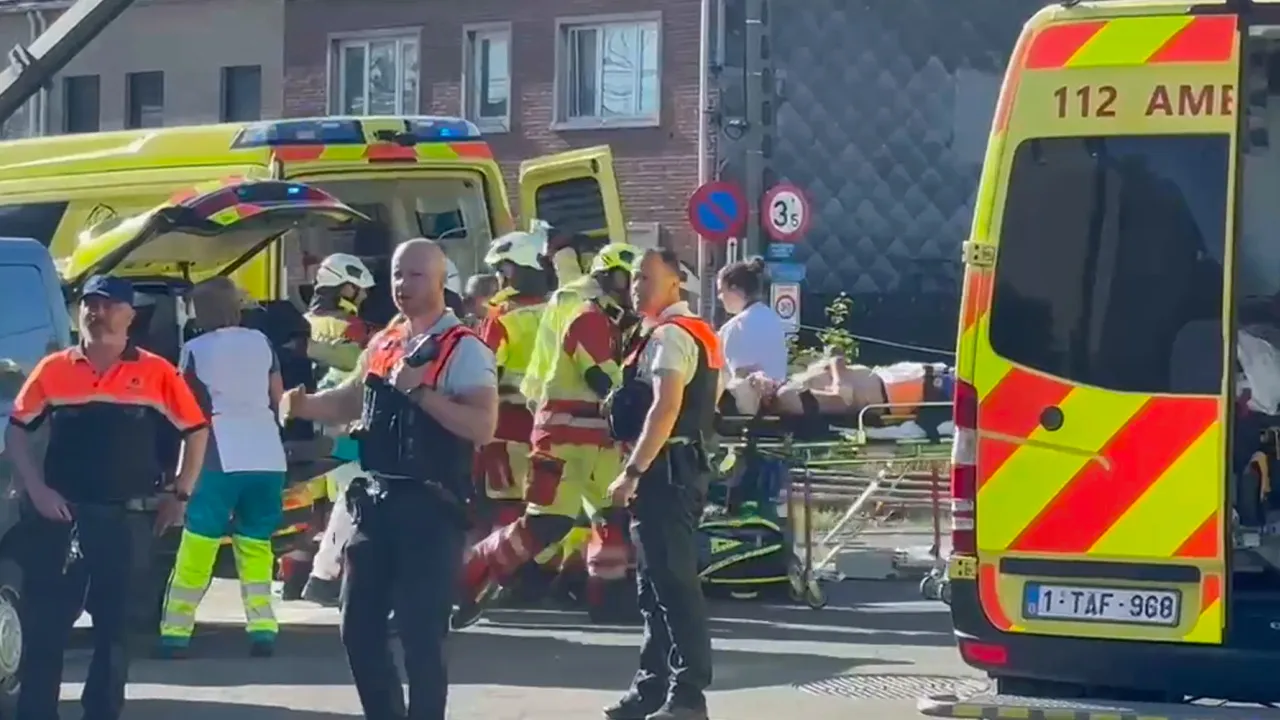 This video grab shows rescue workers on the scene of a crash between a train and vehicle in Buggenhout, Belgium, Tuesday, May 26, 2026. (VTM via AP)