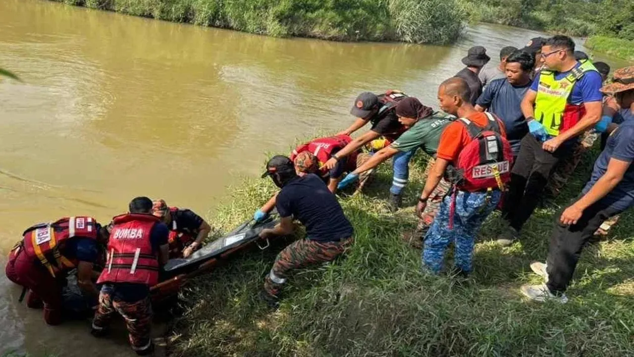 Anggota bomba mengangkat mayat mangsa yang ditemukan tidak jauh dari lokasi jatuh. -- SINAR HARIAN