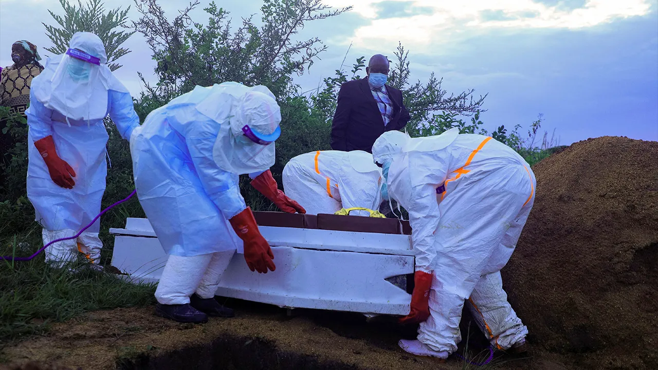 Congolese medical workers wearing personal protective equipment (PPE) prepare to bury the coffin of a patient who died of Ebola, as authorities intensify efforts to contain a new Ebola outbreak involving the Bundibugyo strain outbreak in Rwampara outside Bunia, Ituri province, Democratic Republic of Congo, May 21, 2026. REUTERS/Stringer