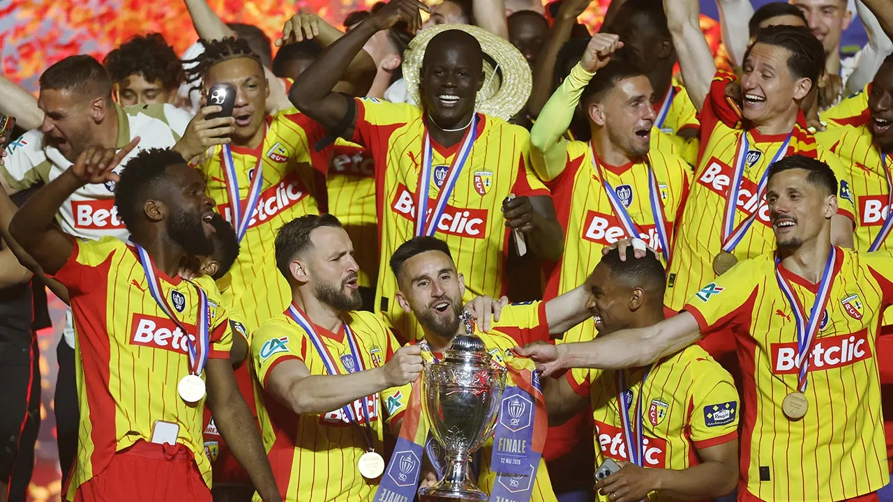 Soccer Football - Coupe de France - Final - RC Lens v OGC Nice - Stade de France, Saint Denis, France - May 22, 2026 RC Lens' Adrien Thomasson lifts the trophy as he celebrates with teammates after winning the Coupe de France REUTERS/Stephane Mahe