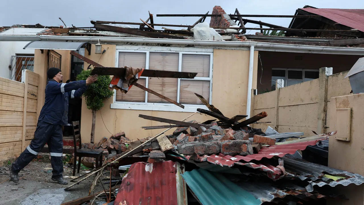 A man removes debris from a damaged house following severe weather in Cape Town, South Africa, May 11, 2026. REUTERS/Esa Alexander