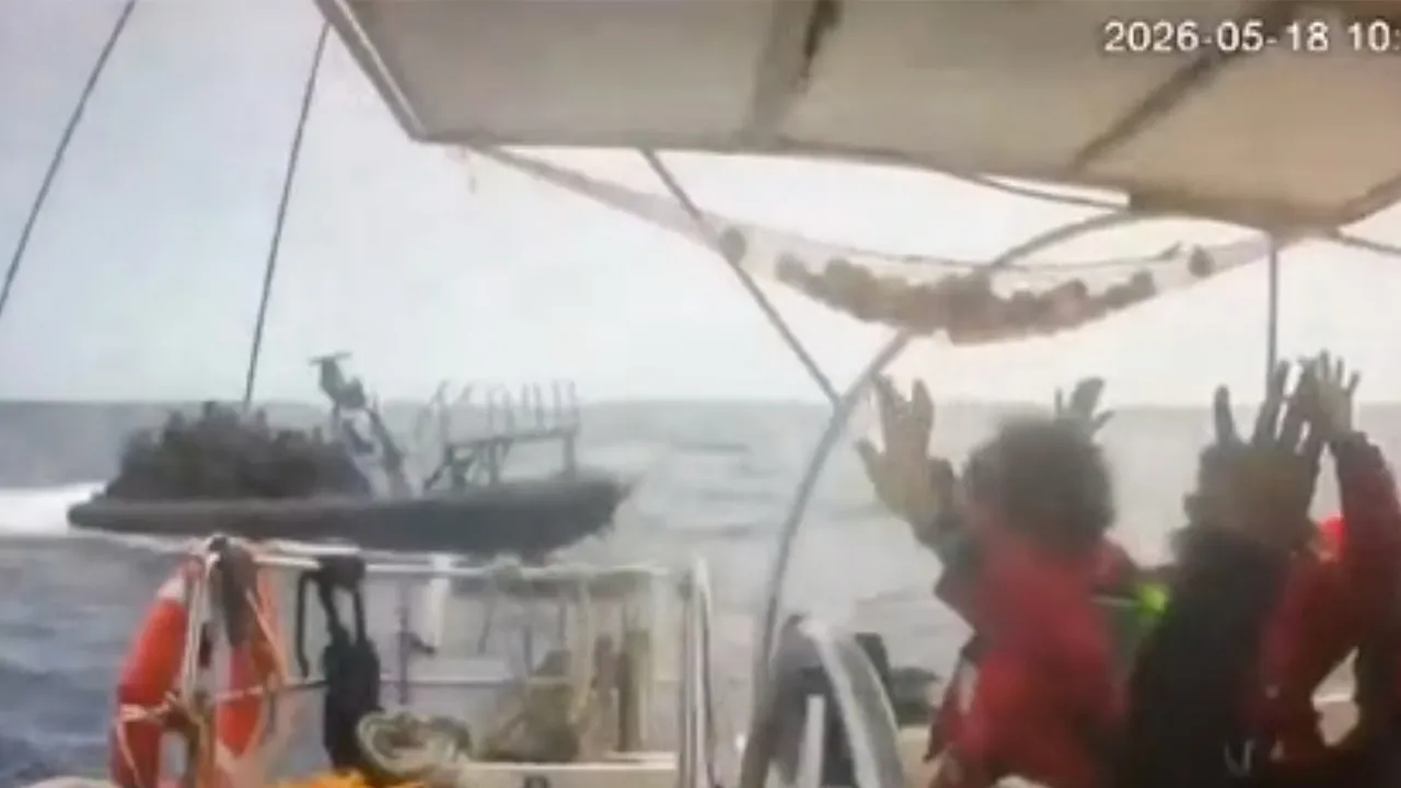 This grab from CCTV footage shows activists aboard a flotilla boat with their hands in the air as a boat approaches one of more than 50 vessels that departed from the port of Marmaris, Turkey, last week in what organizers of the Global Sumud Flotilla described as the final leg of their planned journey to Gaza's shores, in international waters Monday, May 18, 2026. (Global Sumud Flotilla via AP)