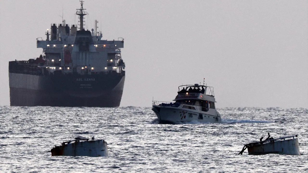 Israeli soldiers are seen on a vessel bearing symbols of the Global Sumud Flotilla, with a cargo ship behind it, as seen from Ashdod, southern Israel, May 19, 2026. REUTERS/Amir Cohen