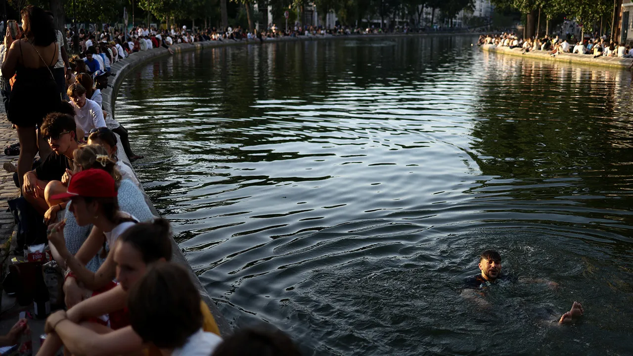 A person swims in the Canal Saint-Martin amid a heatwave in Paris, France, May 28, 2026. REUTERS/Tom Nicholson