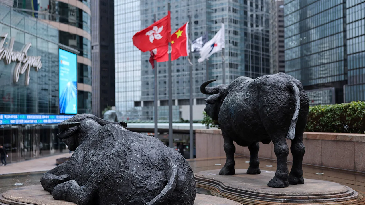Bull statues near screens showing the Hang Seng stock index and stock prices outside Exchange Square, in Hong Kong, China, February 3, 2026. REUTERS/Tyrone Siu/File Photo