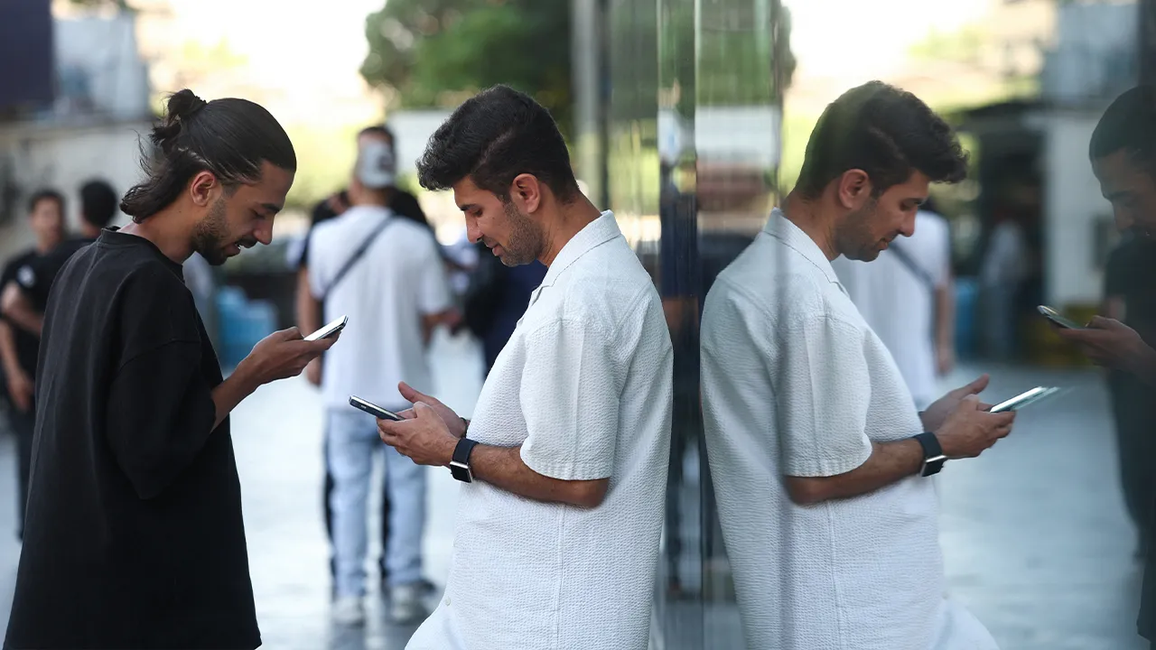 Iranian men use their phones, after a reported reopening of international internet access, in Tehran, Iran, May 27, 2026. Majid Asgaripour/WANA (West Asia News Agency) via REUTERS ATTENTION EDITORS - THIS PICTURE WAS PROVIDED BY A THIRD PARTY. ISRAEL OUT. NO COMMERCIAL OR EDITORIAL SALES IN ISRAEL. NO USE BBC PERSIAN. NO USE VOA PERSIAN. NO USE MANOTO. NO USE IRAN INTERNATIONAL. NO USE RADIO FARDA. DIGITAL: NO USE BBC PERSIAN. NO USE VOA PERSIAN. NO USE MANOTO. NO USE IRAN INTERNATIONAL. NO USE RADIO FARDA.