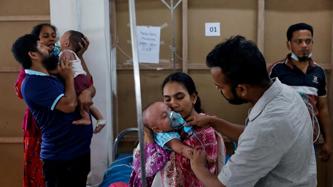 Parents help children infected with measles to adjust their nebuliser masks while receiving treatment at the DNCC Hospital, following an outbreak across the country, in Dhaka, Bangladesh, May 6, 2026. REUTERS/Mohammad Ponir Hossain 