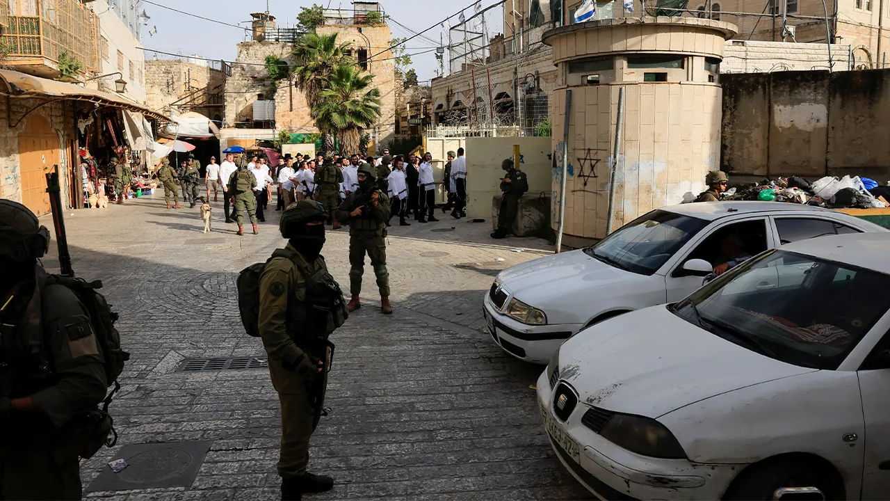 Israeli soldiers stand guard during a weekly settlers' tour in Hebron, in the Israeli-occupied West Bank, May 9, 2026. REUTERS/Mussa Qawasma