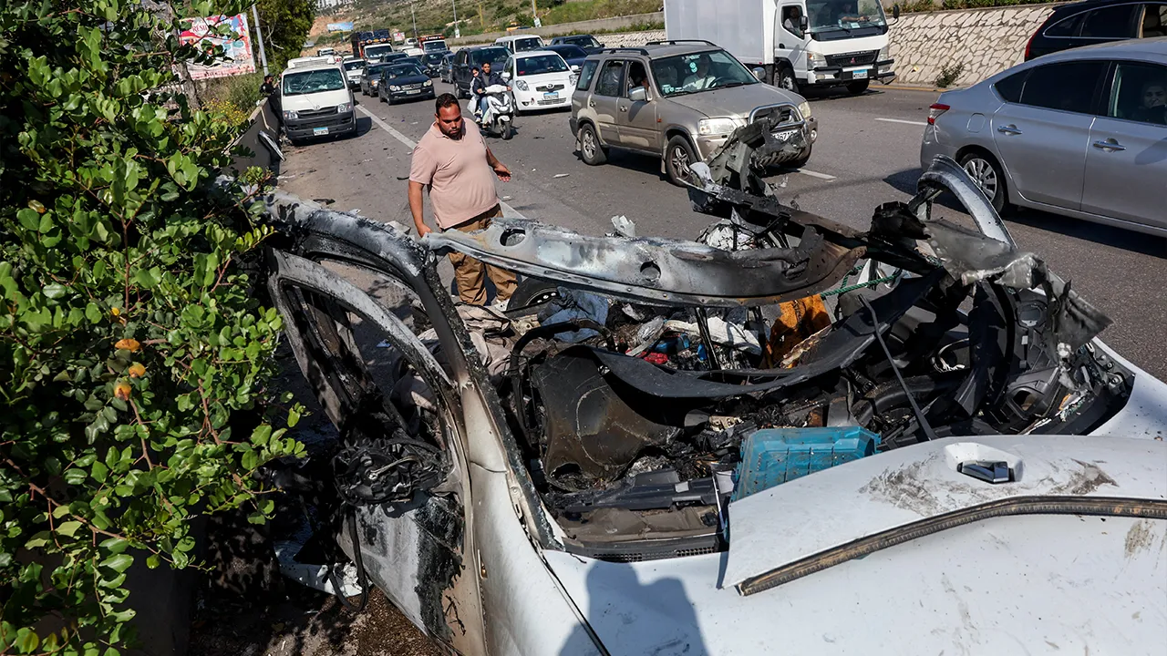 A man looks towards a destroyed car that was targeted by an Israeli strike, in Saadiyat, Lebanon, May 9, 2026. REUTERS/Mohamed Azakir