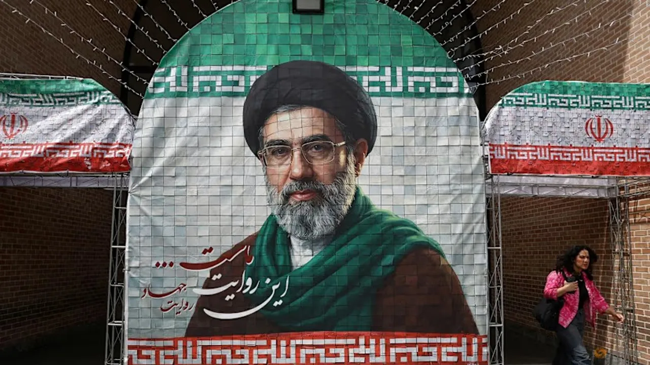 A woman walks next to a banner with a picture of Iran's new Supreme Leader Mojtaba Khamenei in Tehran, Iran on May 8, 2026. (File photo: Reuters/Majid Asgaripour)