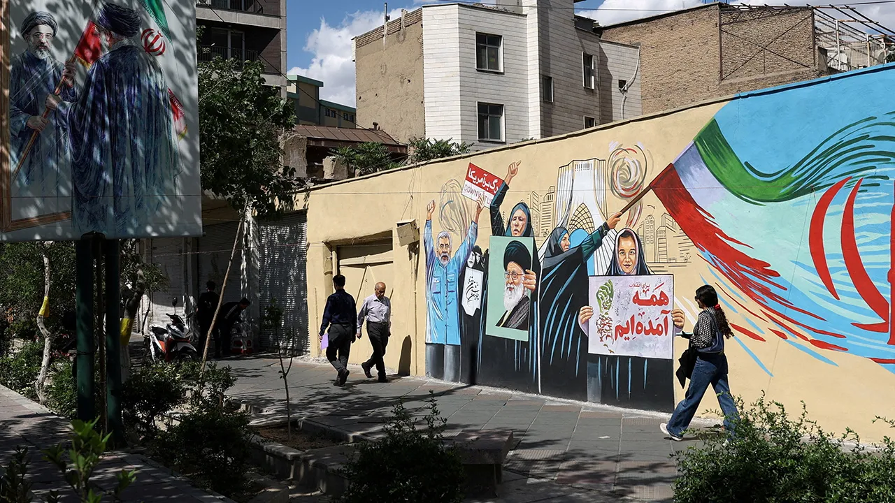People walk on a street near a mural featuring an image of the late Supreme Leader of Iran, Ayatollah Ali Khamenei, in Tehran, Iran, May 18, 2026. Majid Asgaripour/WANA (West Asia News Agency) via REUTERS ATTENTION EDITORS - THIS PICTURE WAS PROVIDED BY A THIRD PARTY TPX IMAGES OF THE DAY