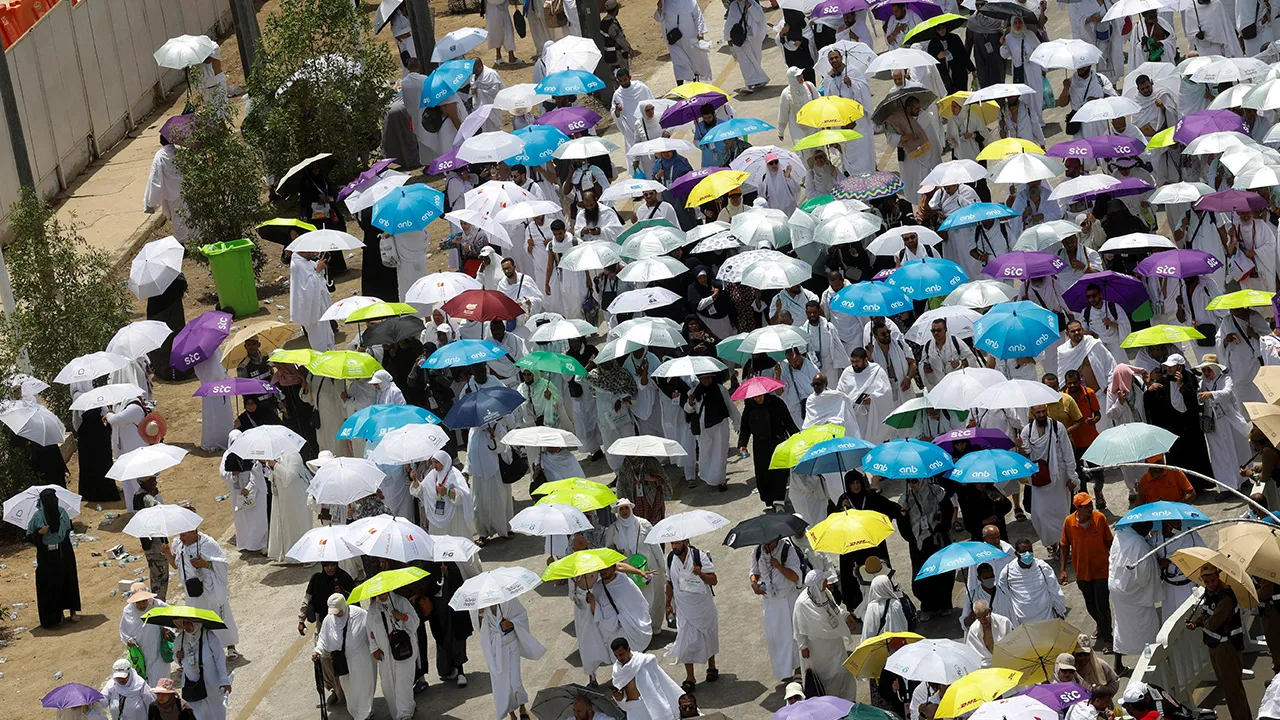 Muslim pilgrims use umbrellas to shield themselves from the sun after noon prayers outside Nimrah Mosque at the Plain of Arafat during the annual hajj pilgrimage, outside the holy city of Mecca, Saudi Arabia, May 26, 2026. REUTERS/Ibraheem Abu Mustafa REFILE - QUALITY REPEAT
