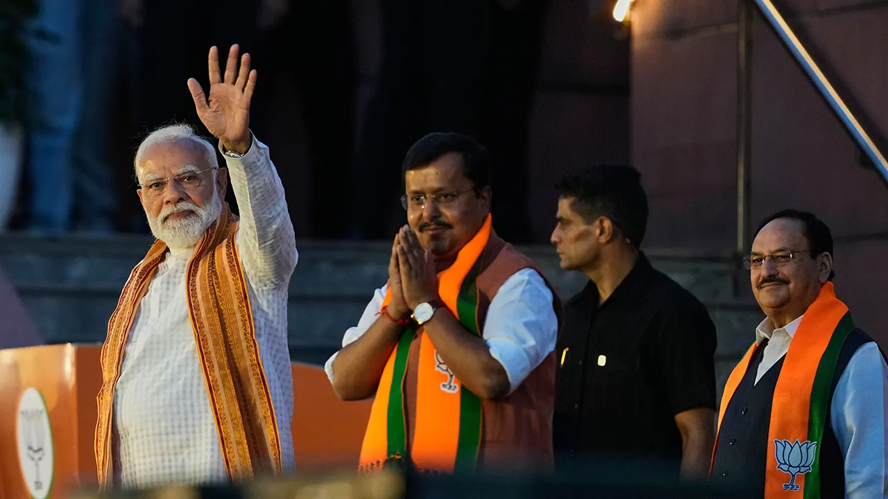 Indian Prime Minister Narendra Modi, left, waves at the party headquarters in New Delhi, India, Monday, May 4, 2026, as Bharatiya Janata Party (BJP) president Nitin Nabin and former party president JP Nadda, right, watch during a victory celebration in the recently held state assembly elections. (AP Photo/Manish Swarup)