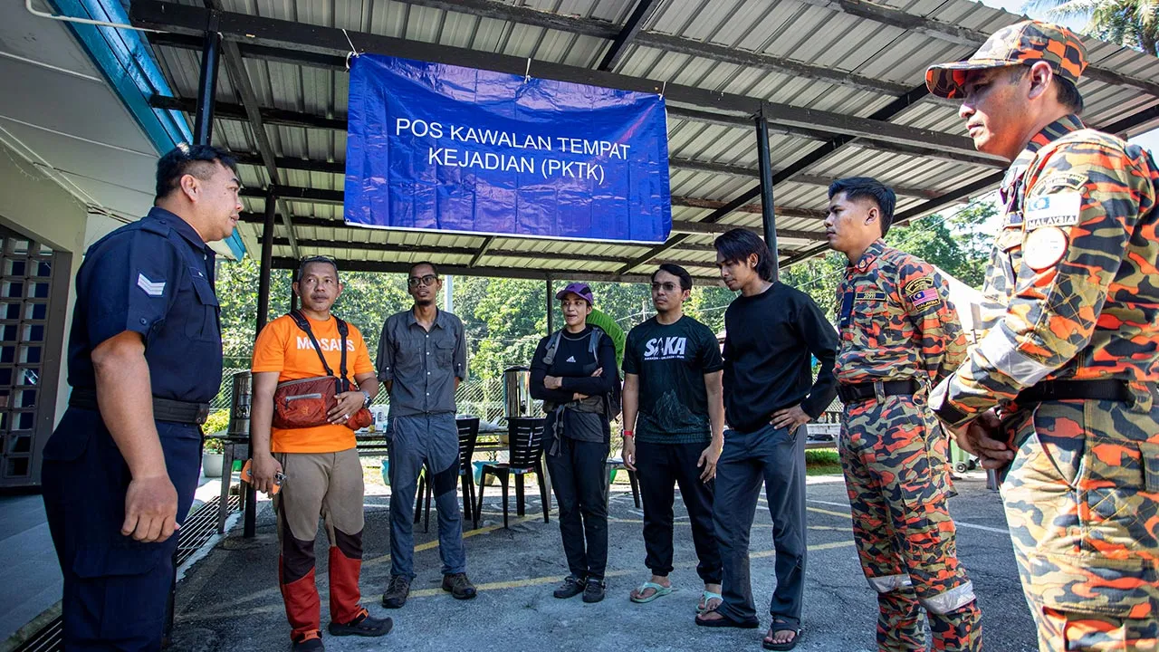 TAPAH, 26 Mei -- Penyelia Pos Kawalan Sarjan Ali Aluie (kiri) menerangkan perancangan operasi mencari dan menyelamat (SAR) mangsa Jaslinda Saludin, 49, yang dilaporkan hilang ketika menyertai pendakian di Gunung Batu Putih pada Ahad lepas, di Pos Kawalan Tempat Kejadian (PKTK) di Pos Kuala Poh hari ini.  Penolong Pengarah Bahagian Operasi Jabatan Bomba dan Penyelamat (JBPM) Perak Sabarodzi Nor Ahmad berkata operasi SAR akan difokuskan di sekitar laluan menghala ke Gunung Rayu dan Pos Musoh yang dipercayai b