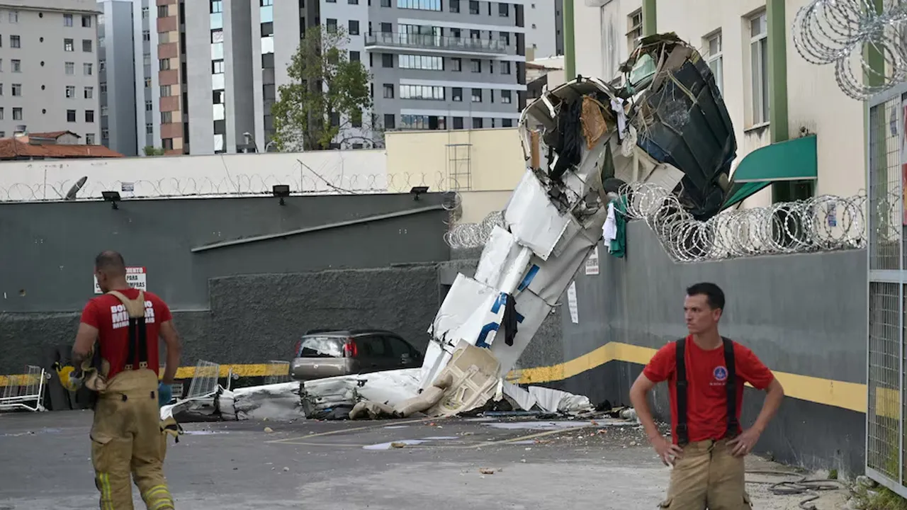 Firefighters work next to the remains of a plane after it crashed into a building in Belo Horizonte, Brazil, May 4, 2026. REUTERS/Washington Alve