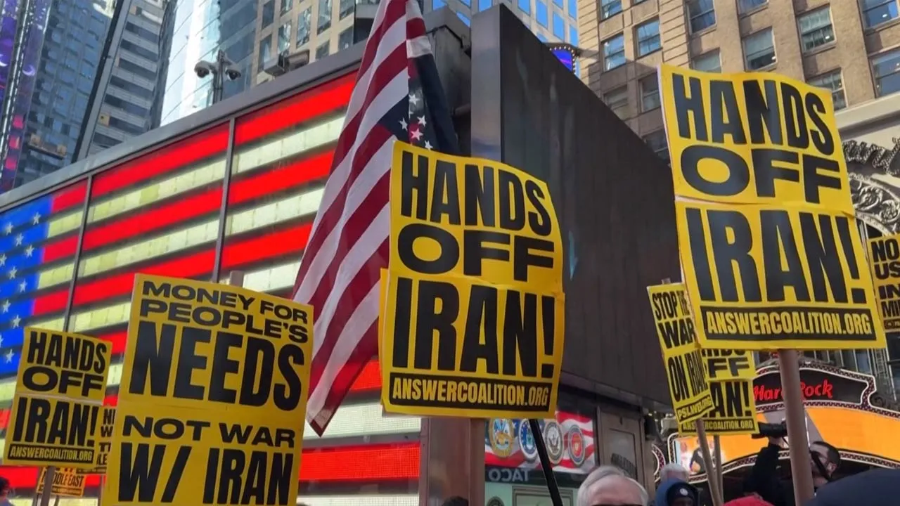 PEOPLE HOLDING SIGNS DURING PROTEST AS POLICE OFFICERS LOOK ON