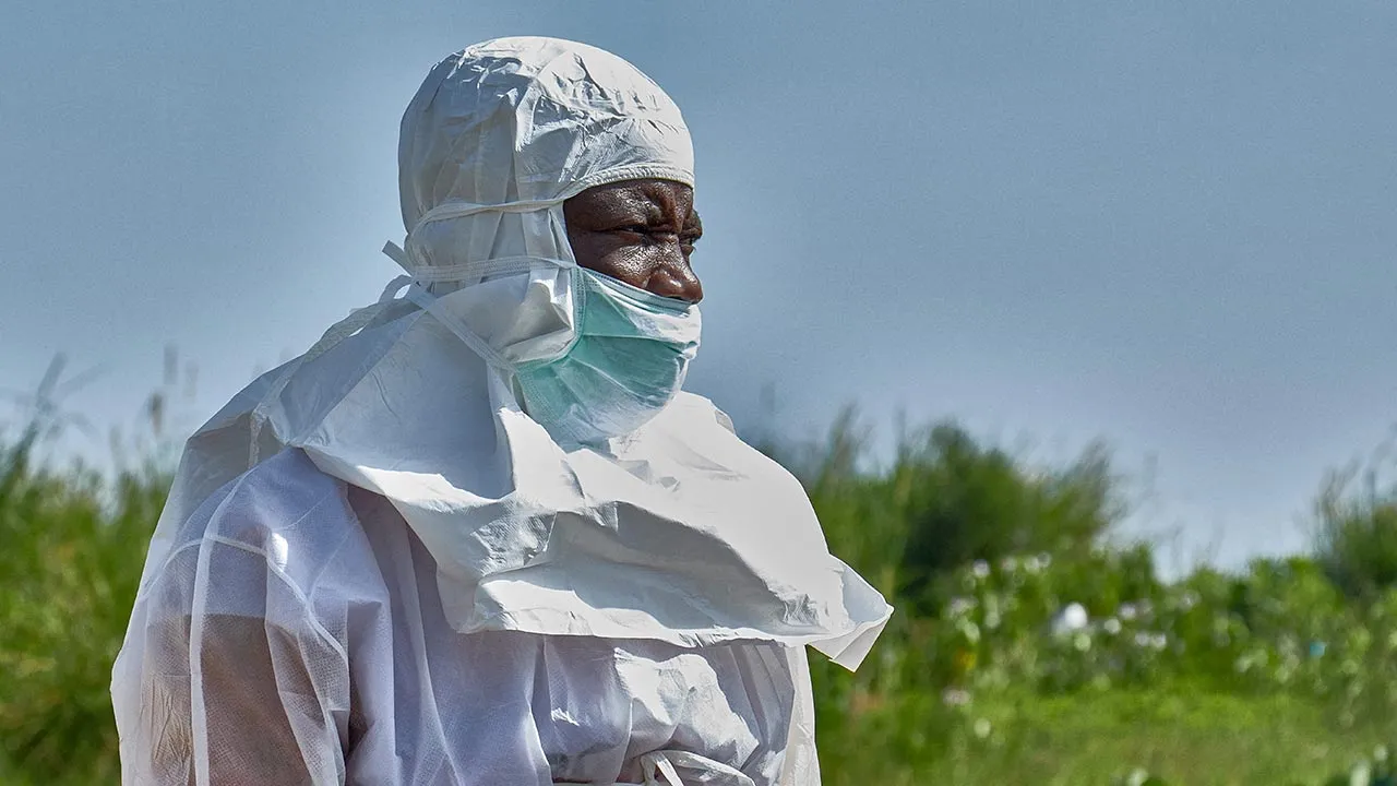 FILE PHOTO: A Red Cross worker wearing personal protective equipment (PPE) attends the burial of Dr Tibenderana Katho Blaise who worked at the Centre Medical Evangelique (CME) in Hoho commune and died of Ebola virus, as aid agencies intensify efforts to contain a new Ebola outbreak caused by the Bundibugyo virus, at the Nyamurongo cemetery in Bunia town, Ituri province, Democratic Republic of Congo, May 26, 2026. REUTERS/Gradel Muyisa Mumbere/File Photo