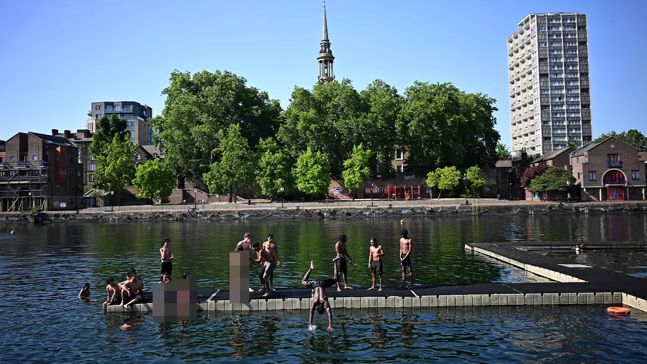 Locals cool off as they relax on a jetty in the Shadwell Basin, fed by the Thames River, during a heatwave in London, Britain, May 26, 2026. REUTERS/Dylan Martinez