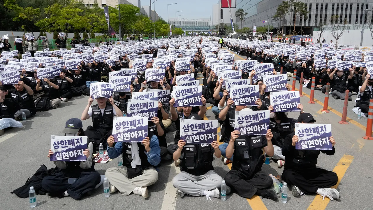 FILE - Members of the Samsung Electronics labor union hold up their cards during a rally demanding higher bonuses at its computer chip complex in Pyeongtaek, South Korea, on April 23, 2026. The letters read "Remove the bonuses caps." (AP Photo/Ahn Young-joon, File)