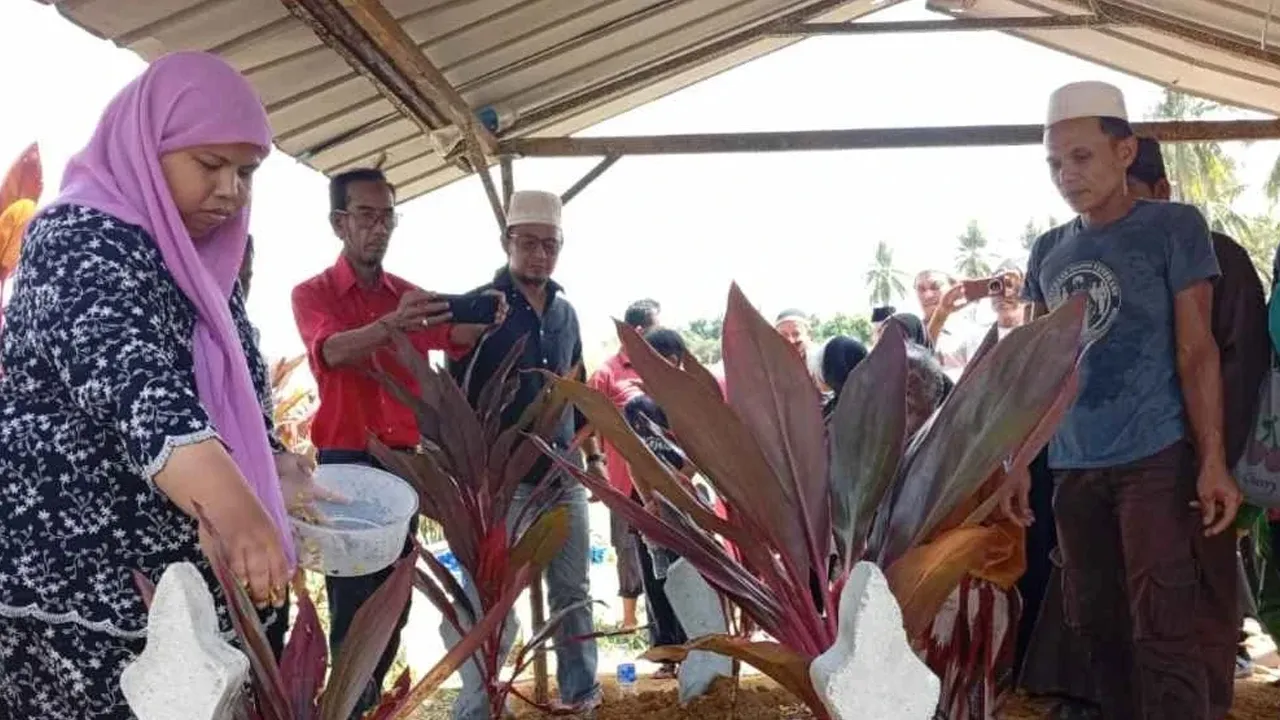Ibu mangsa, Suria Sulong dan bapa, Nur Shahila, Azman Wahab ketika urusan pengebumian di Tanah Perkuburan Islam Jeram Manir,Kuala Terengganu pada Rabu.