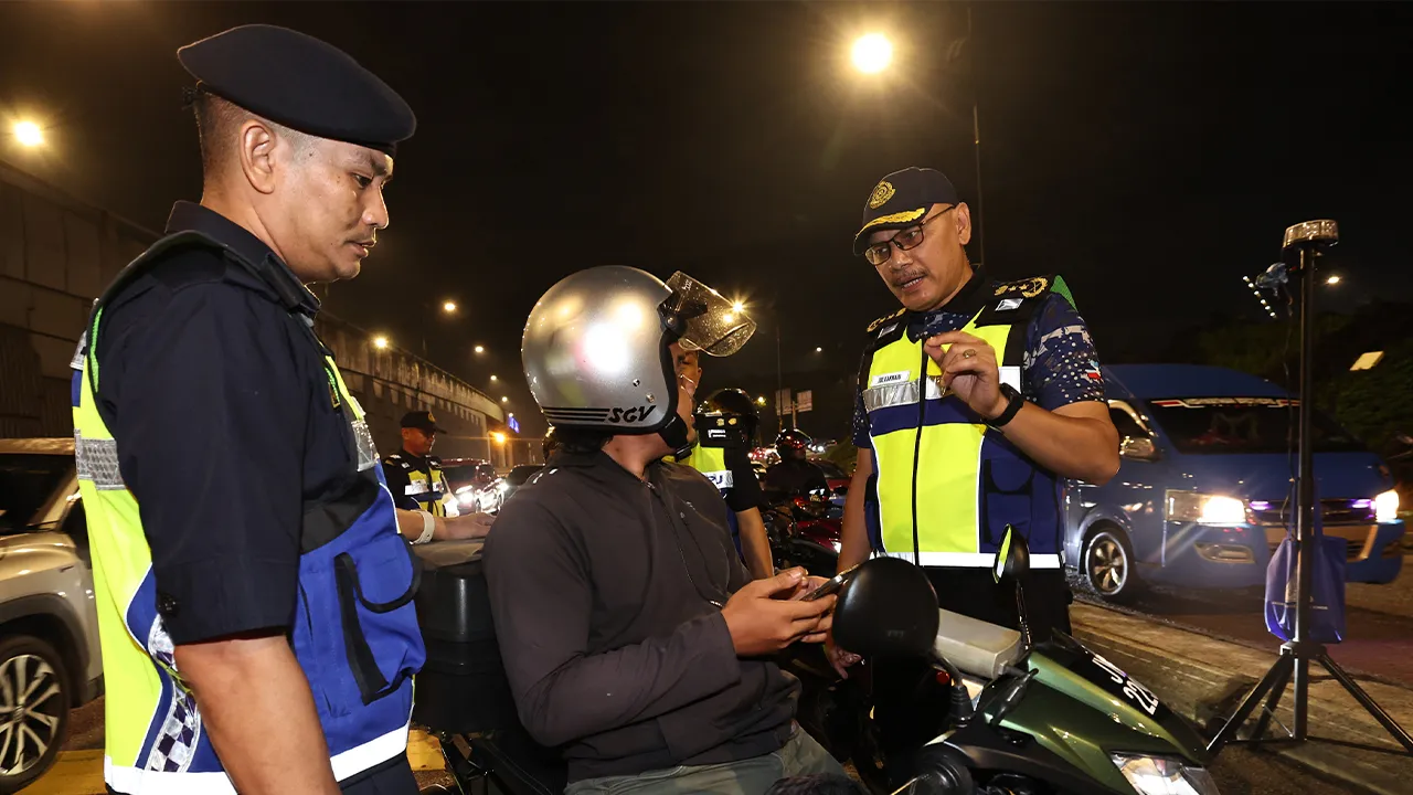 JOHOR BAHRU, 7 Mei -- Pengarah Jabatan Pengangkutan Jalan (JPJ) Negeri Johor, Zulkarnain Yasin, (kanan) memeriksa dokumen salah satu motosikal pada Ops Satu Johor secara besar-besaran melibatkan seluruh daerah di negeri berkenaan di jalan susur Skudai-Pontian di sini malam ini.  --fotoBERNAMA (2026) HAK CIPTA TERPELIHARA