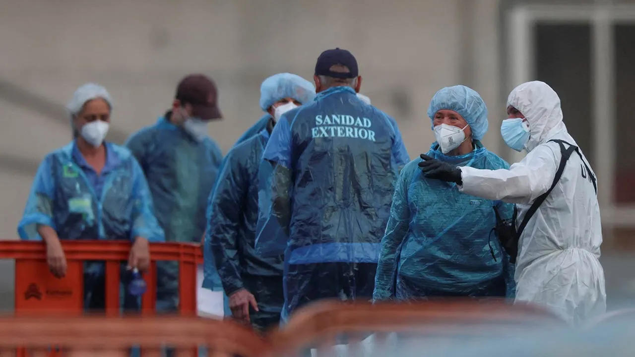 U.S. passengers from the cruise ship MV Hondius, affected by a hantavirus outbreak, stand on land after disembarking the ship, at the port of Granadilla de Abona, in Tenerife, Spain, May 10, 2026. REUTERS/Hannah McKay