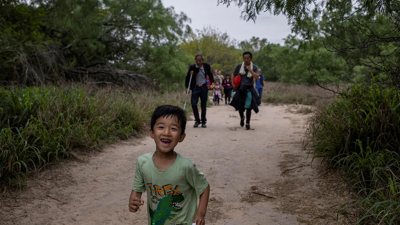 A five-year-old migrant boy from China chases his brother down a trail after he and his family crossed the Rio Grande river into the United States from Mexico in Fronton, Texas, U.S., April 5, 2023. REUTERS/Staff/File Photo