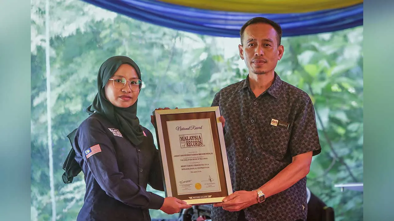 KANGAR, 7 Jun -- Pengarah Perhutanan Perlis Ag Shaffie Ag Ahmadni (kanan) menerima Sijil Pengiktirafan Malaysia Book of Record (MBOR) daripada Ketua Bahagian Rekod dan Penyelidikan MBOR Siti Nurhanim Mohd Noh pada Majlis Perasmian Penutup Nawakan Rainforest Festival 2026 sempena Hari Hutan Sedunia Peringkat Negeri Perlis di Kompleks Ekopelancongan Sungai Batu Pahat hari ini.  Jabatan Perhutanan Negeri Perlis menerima pengiktirafan ‘Bilangan Gua Terbanyak Disurvei dalam Satu Ekspedisi Speleologi’.  -- fotoBE