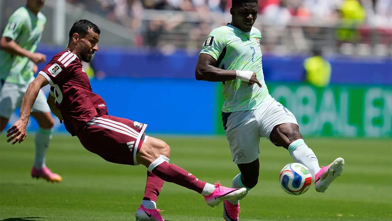 Qatar's Boualem Khoukhi, left, and Switzerland's Breel Embolo fight for the ball during the World Cup Group B soccer match between Qatar and Switzerland in Santa Clara, Calif., near San Francisco, Saturday, June 13, 2026. (AP Photo/Eugene Hoshiko)