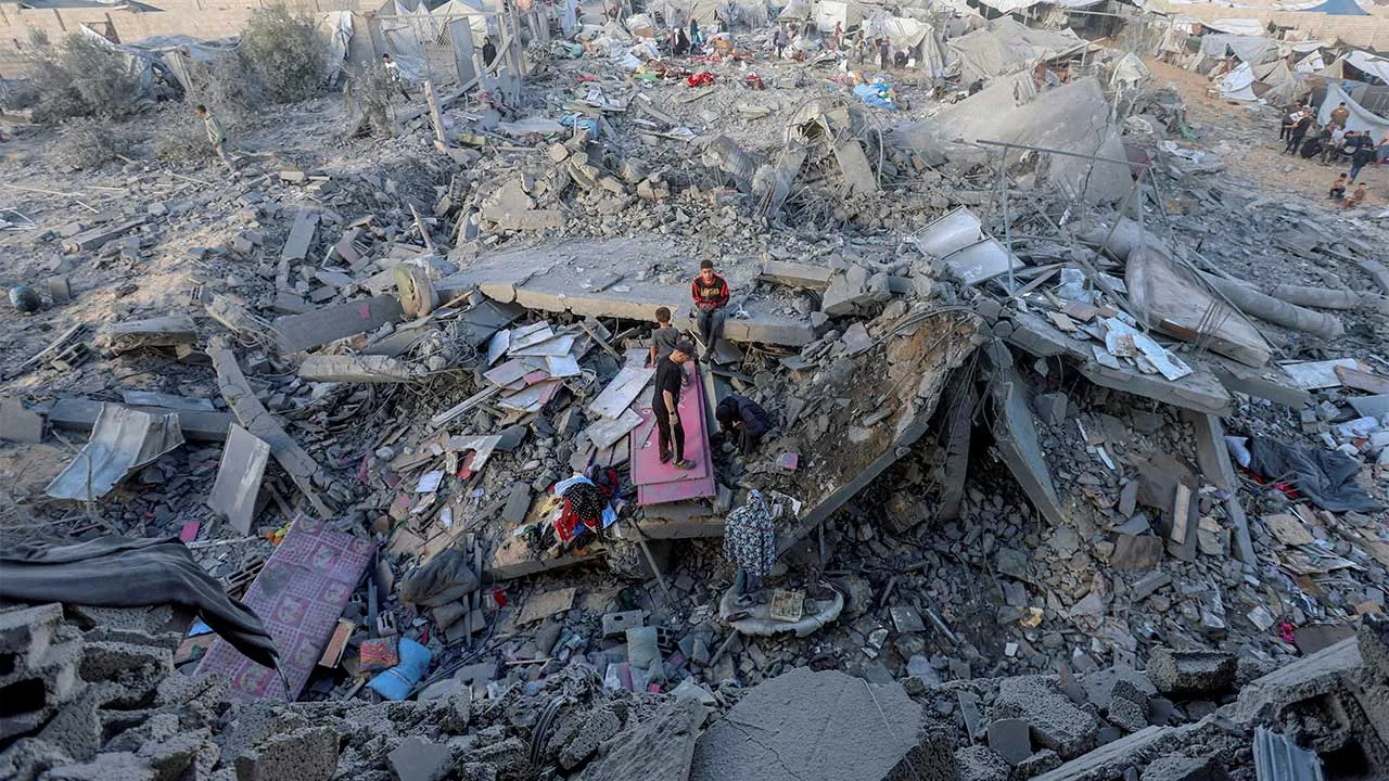 Palestinians inspect the site of an Israeli strike on a house whose residents were warned to evacuate before the attack, near a tent camp sheltering displaced people that was damaged in the strike, in Khan Younis in the southern Gaza Strip June 7, 2026. REUTERS/Ramadan Abed REFILE - QUALITY REPEAT TPX IMAGES OF THE DAY