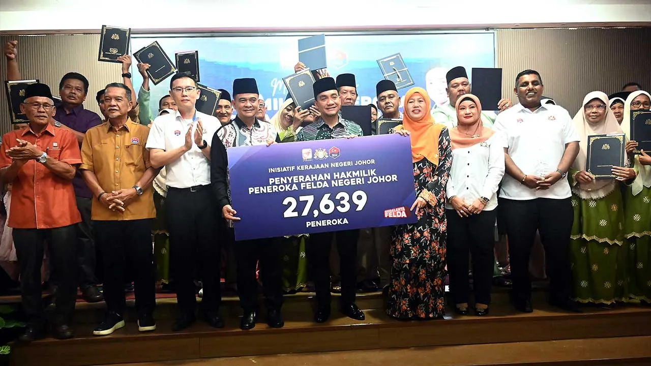 KLUANG, 23 Jun --Menteri Besar Johor, Datuk Onn Hafiz Ghazi (depan, tengah) memegang replika kad yang menunjukkan jumlah penerima geran hak milik peneroka FELDA Negeri Johor pada Majlis Penyerahan Geran Hak Milik Peneroka FELDA Negeri Johor di Dewan Dato' Onn, Rumah Komuniti Parlimen Sembrong, hari ini.  Turut kelihatan para penerima geran yang melibatkan daerah Kluang, Kota Tinggi dan Mersing.  fotoBERNAMA (2026) HAK CIPTA TERPELIHARA