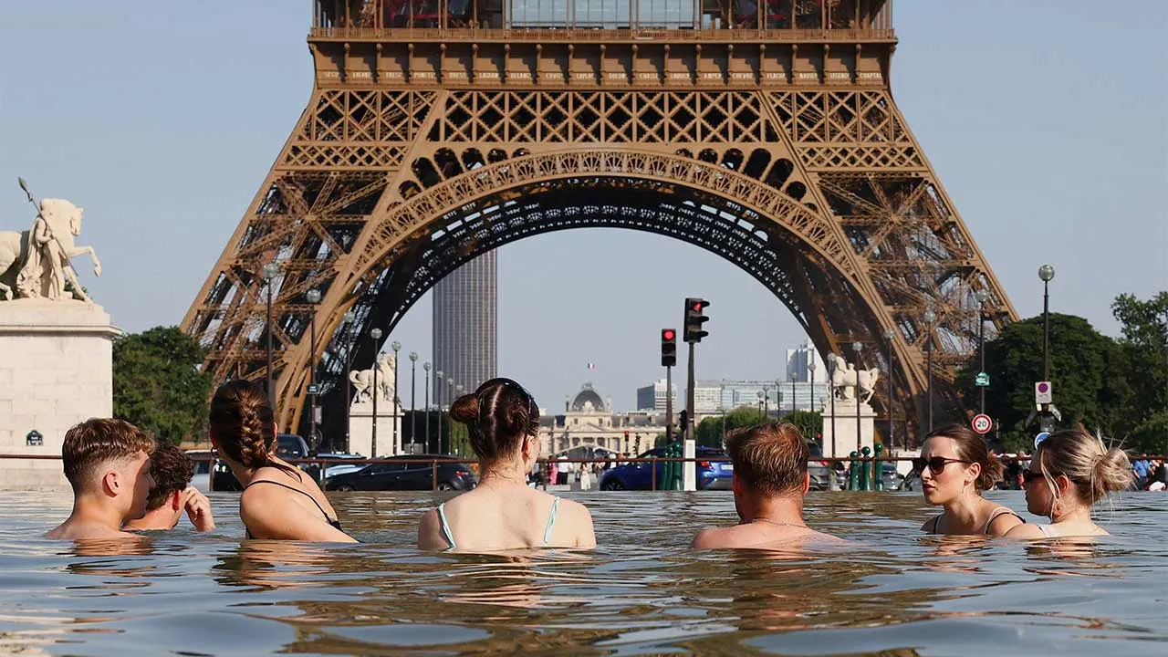 People cool off in the Trocadero Fountain next to the Eiffel Tower as temperatures rise during a heatwave affecting a large part of the country, in Paris, France, June 22, 2026. REUTERS/Abdul Saboor