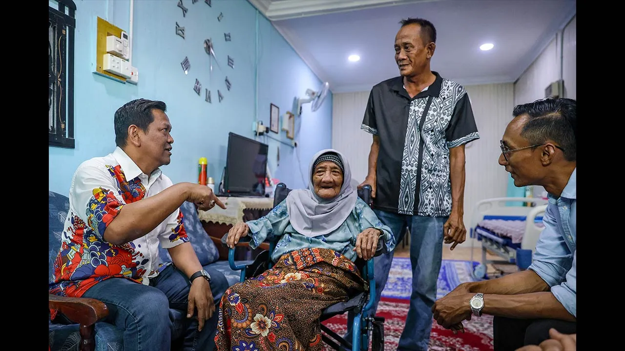 MERSING, 23 Jun -- Setiausaha Politik kepada Menteri Komunikasi, Abdullah Izhar Yusof (kiri) menyantuni warga emas, Zainon Ibrahim, 91, (dua, kiri) dan anaknya, Jamaluddin Ismail, 64, (dua, kanan) sempena Program Ziarah Kasih di Jalan Merbuk, Rumah Murah Endau, hari ini.