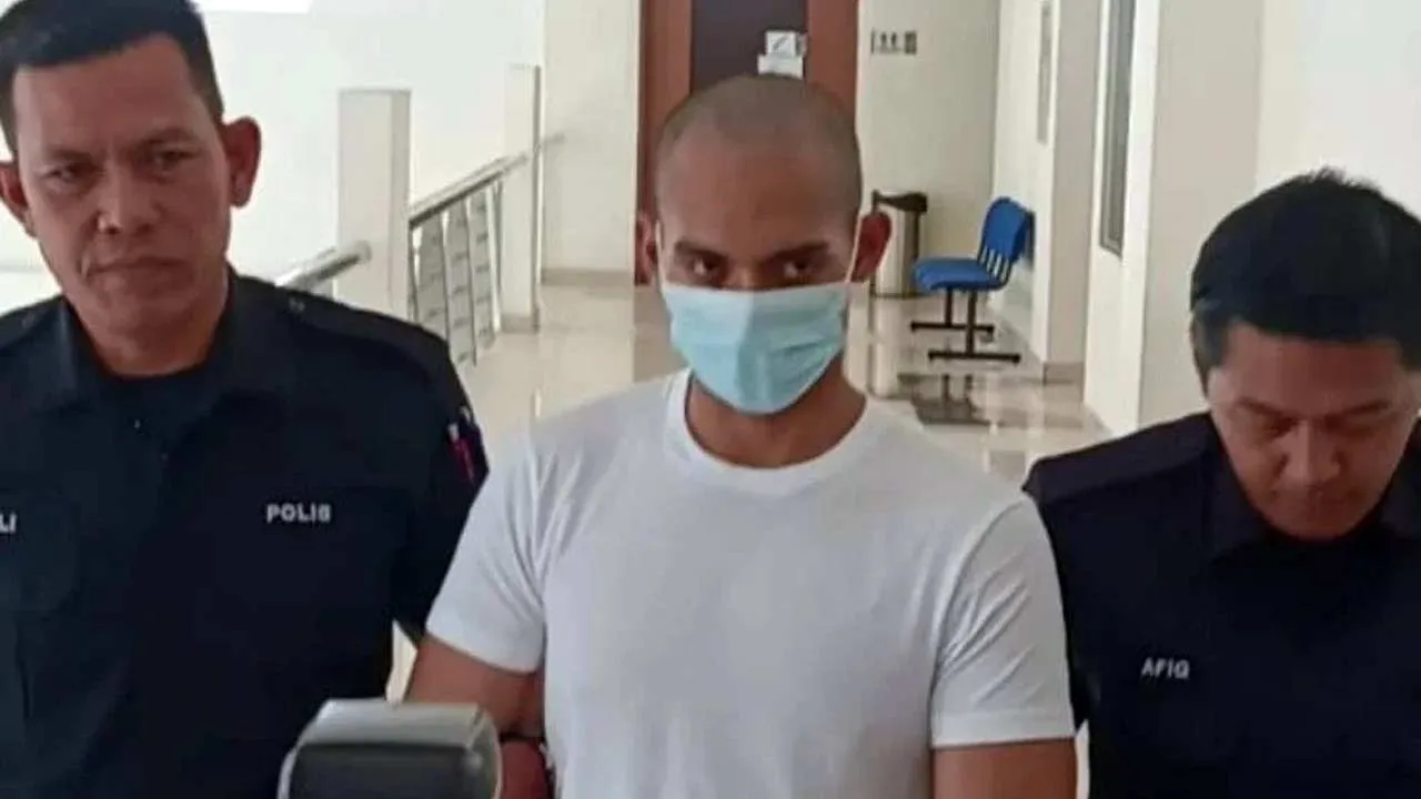 Amirul Amin memakai baju-T putih ketika dibawa keluar dari Mahkamah Tinggi Klang selepas dijatuhi hukuman penjara 32 tahun dan 12 sebatan kerana membunuh kekasihnya dengan menekup muka mangsa menggunakan bantal.