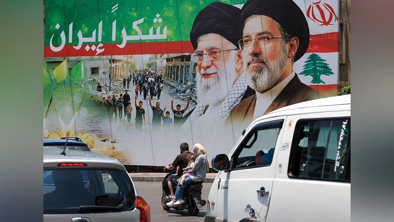 A family ride on a motorcycle past a banner that reads "Thank you Iran" following a deal between the U.S. and Iran, in the southern suburbs of Beirut, Lebanon, June 15, 2026.REUTERS/Mohamed Azakir