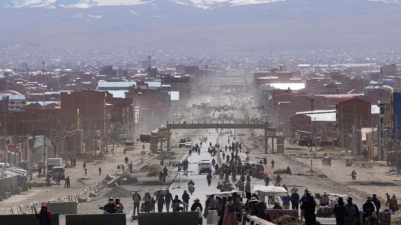 Residents walk on a highway after President Rodrigo Paz declared a state of emergency to empower the military to remove road blockades, in El Alto, Bolivia, Saturday, June 20, 2026. (AP Photo/Juan Karita)