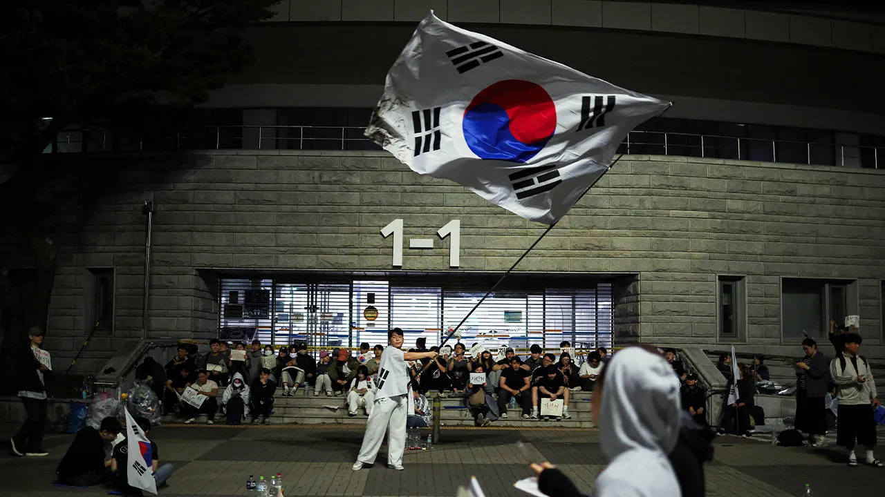 A demonstrator waves a large South Korean flag as people surround a vote-counting centre to protest a controversy over a shortage of ballot papers that disrupted voting in the local election and to call for a rerun of the election, in Seoul, South Korea, June 6, 2026. REUTERS/Kim Hong-Ji