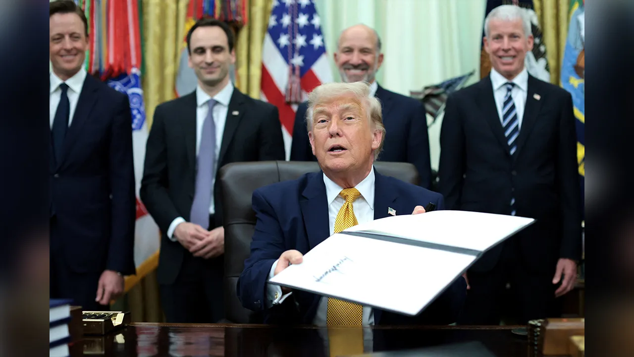 U.S. President Donald Trump holds up a signed executive order regarding quantum computing, in the Oval Office at the White House in Washington, D.C., U.S., June 22, 2026. REUTERS/Jonathan Ernst