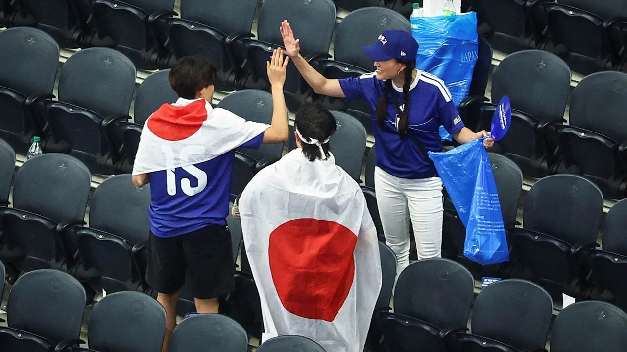 Soccer Football - FIFA World Cup 2026 - Group F - Netherlands v Japan - Dallas Stadium, Arlington, Texas, U.S. - June 14, 2026 Japan fans clear rubbish from the stands after the match REUTERS/Kai Pfaffenbach TPX IMAGES OF THE DAY SEARCH "WORLD CUP DAILY ONE" FOR THIS STORY. SEARCH "WIDER IMAGE" FOR ALL STORIES.