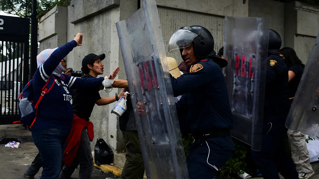 Demonstrators scuffle with riot police during a protest outside the Azteca Stadium during the opening match of the 2026 FIFA World Cup in Mexico City, Mexico, June 11, 2026. REUTERS/Rolando Ramos