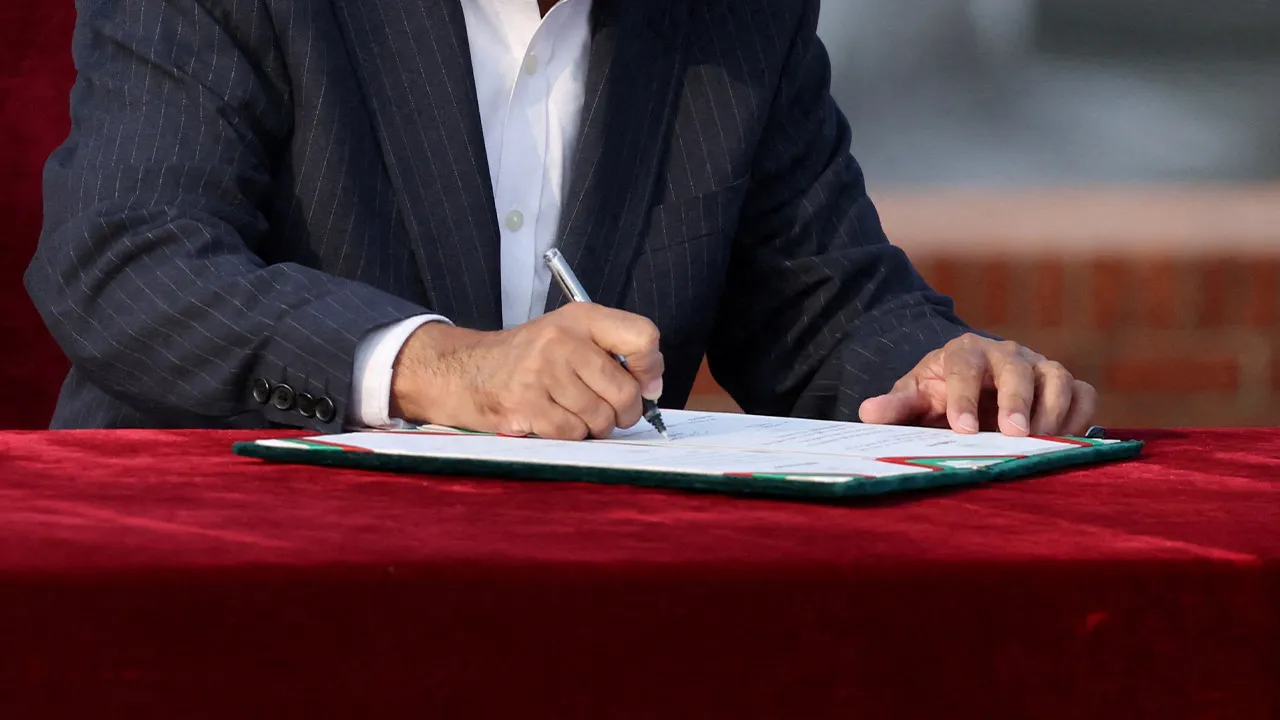 FILE PHOTO: Tarique Rahman signs as new Prime Minister during an oath-taking ceremony administered by Bangladesh’s President Mohammed Shahabuddin, following BNP's landslide victory in the national polls, in Dhaka, Bangladesh, February 17, 2026. REUTERS/Mohammad Ponir Hossain/File Photo