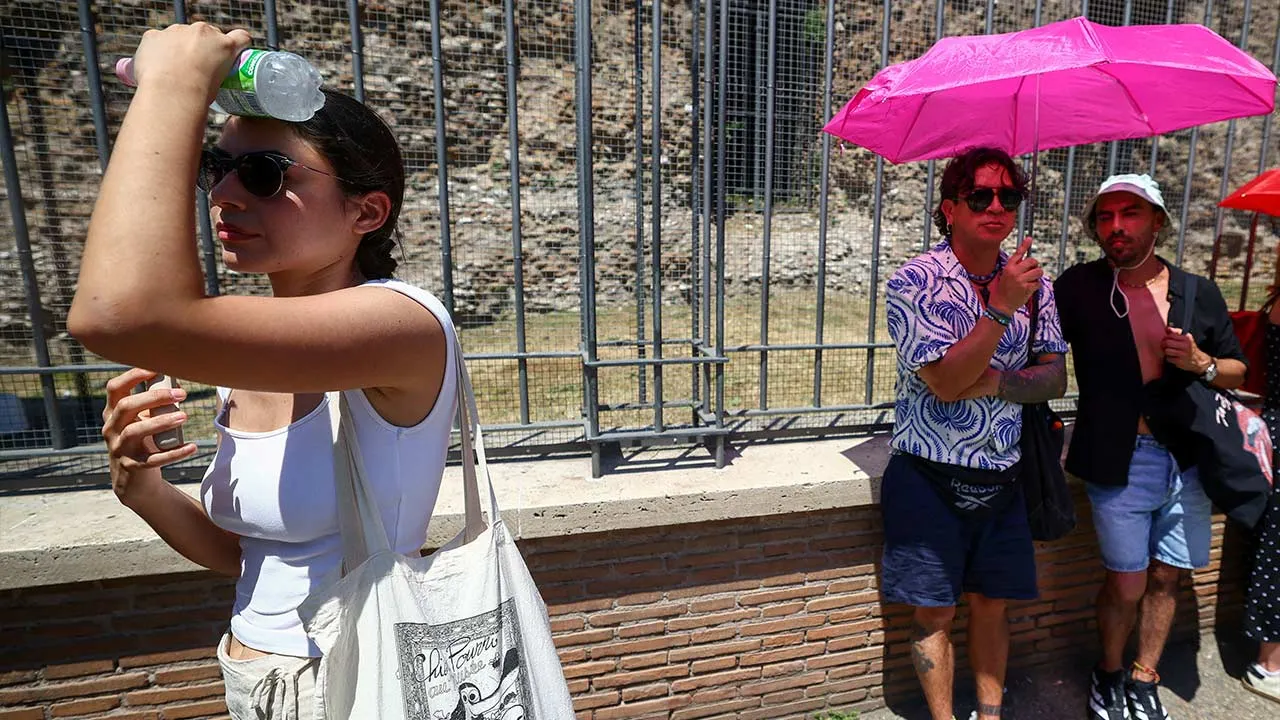 A tourist shields her face from the sun near the Colosseum during a heatwave in Rome, Italy, June 20, 2026. REUTERS/Guglielmo Mangiapane TPX IMAGES OF THE DAY