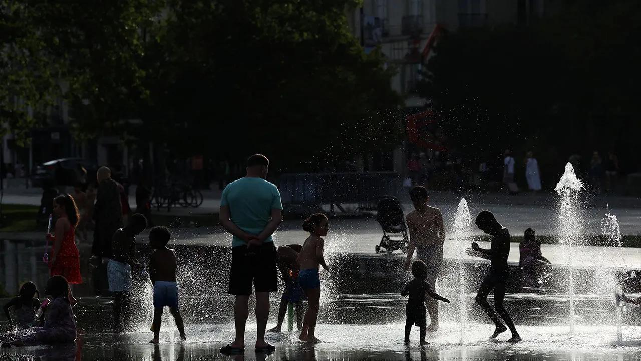 People cool off in the Miroir d'eau (Mirror of Water) in Nantes during a heatwave affecting a large part of France, June 24, 2026. REUTERS/Stephane Mahe
